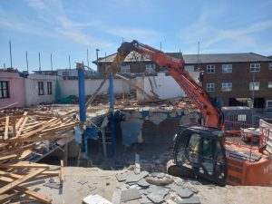 Excavator carrying out demolition of building