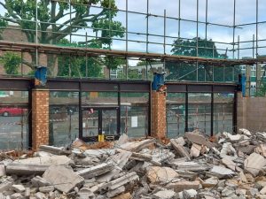 Demolished building rubble and glass wall